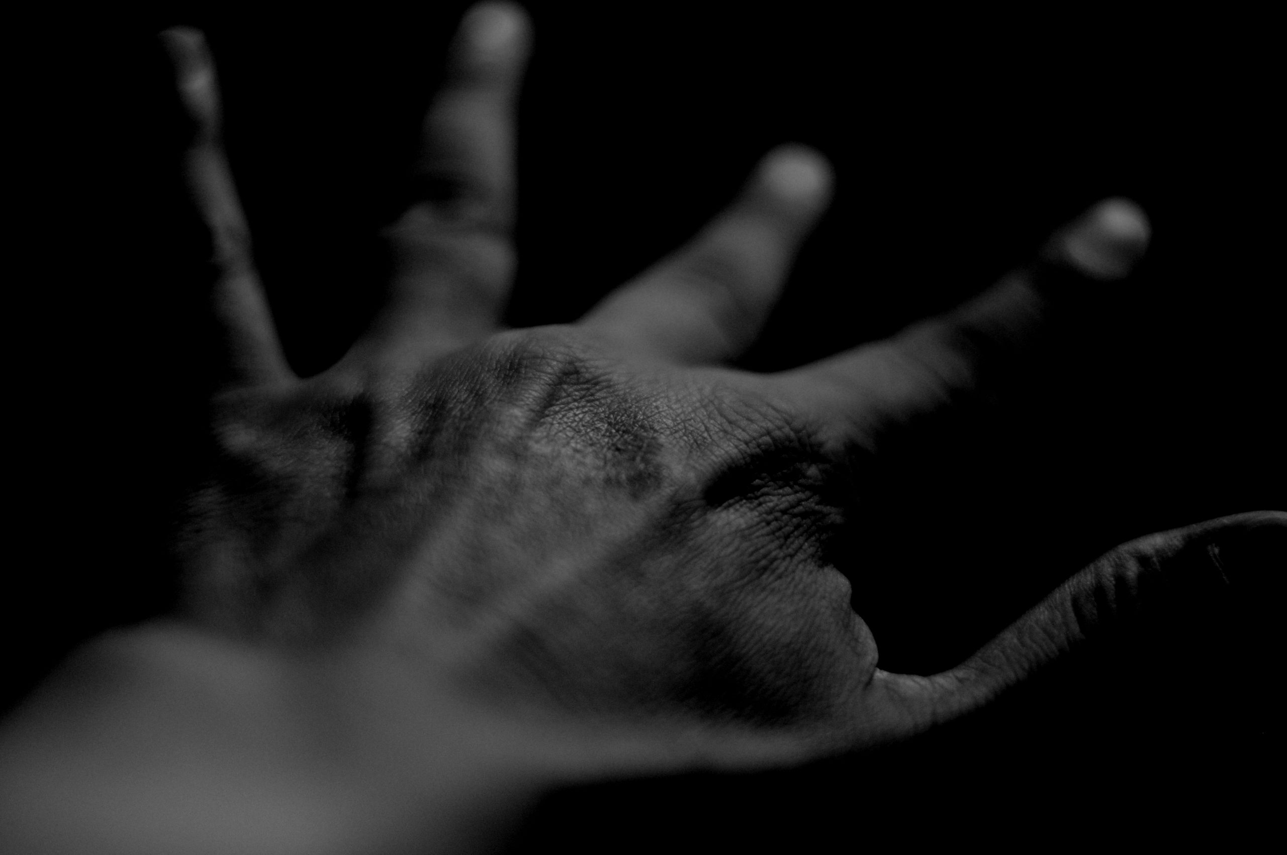 close up human hand against black background scaled