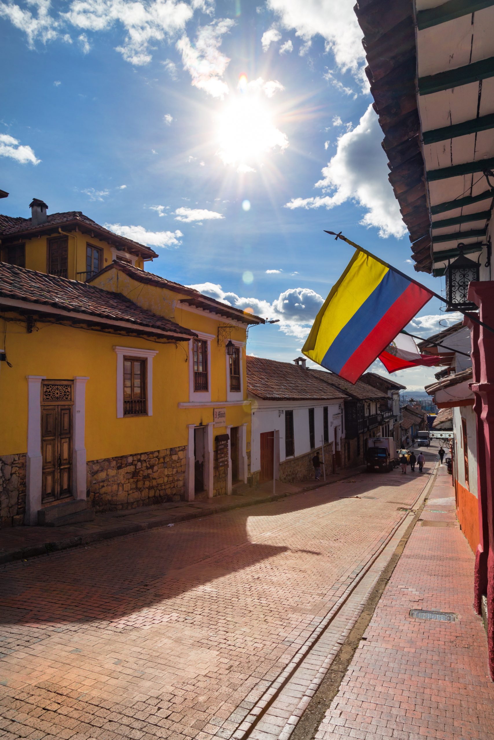 colombian flag flies cobblestone street candelaria neighborhood bogota colombia scaled